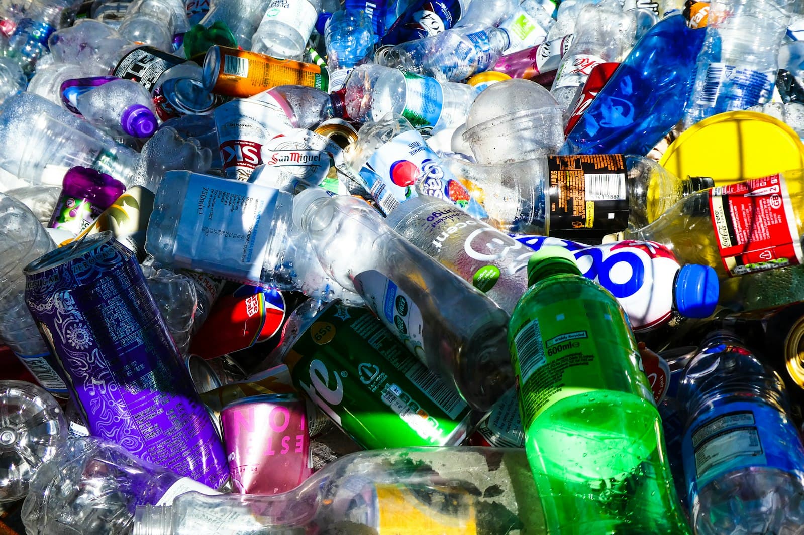 A large pile of discarded plastic bottles and cans collected for recycling